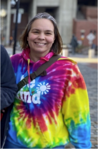 Karen Lockwood is smiling at the camera. She is wearing a colorful tie-dye hoodie